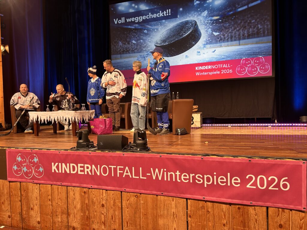 Referenten in Eishockey-Trikots auf der Eventbühne der Kinder-Notfall-Tage in Garmisch-Partenkirchen.