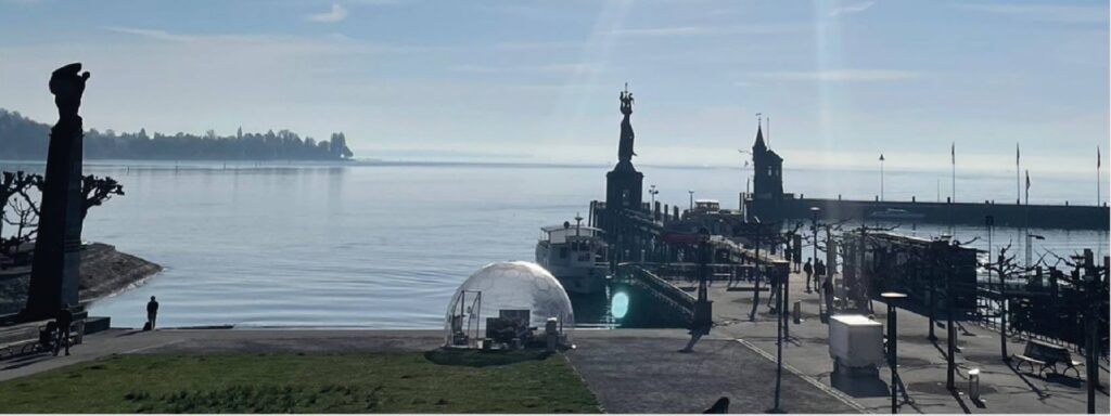 Außenansicht des historischen Konzils Konstanz direkt am Bodenseeufer mit einer Event-Glaskuppel.